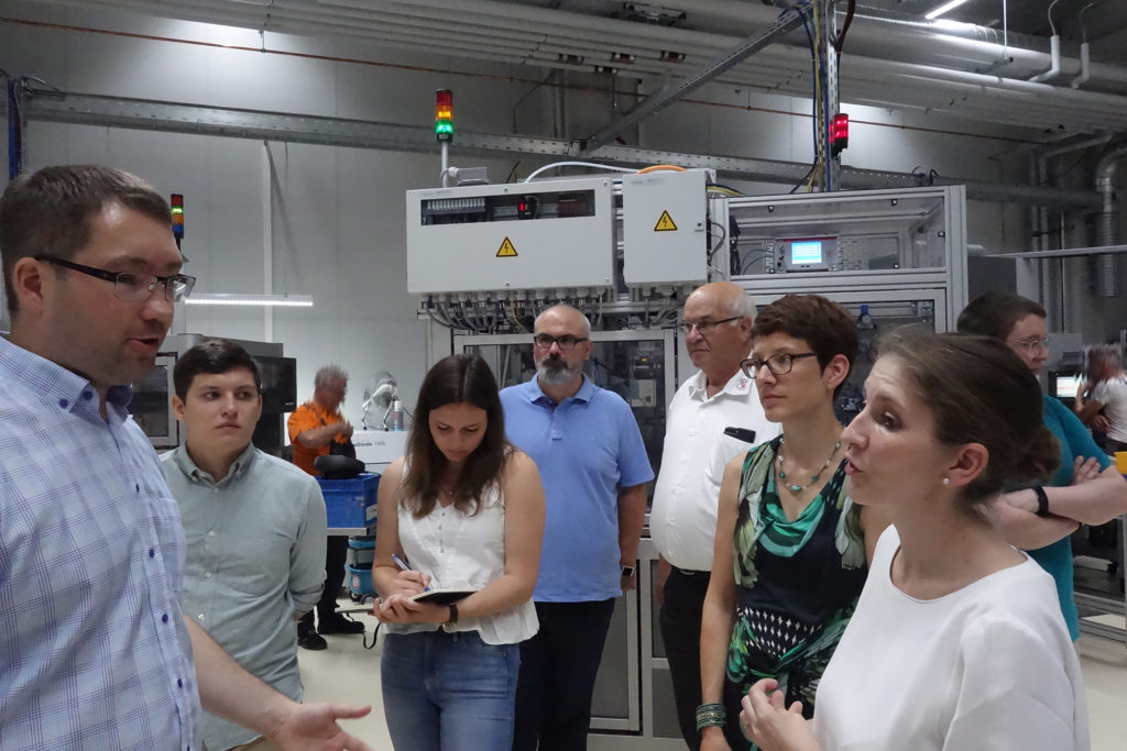 Teile des Forschungsteam vor Produktionsanlagen der SITEC